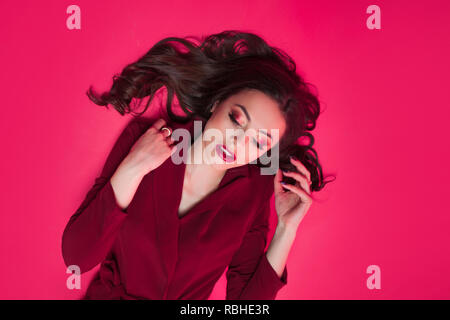 Attractive brunette un ton regard. Portrait of attractive young woman élégant sur fond rose Banque D'Images