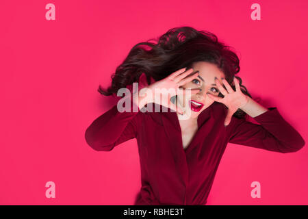 Attractive brunette un ton regard. Portrait of attractive young woman élégant sur fond rose Banque D'Images