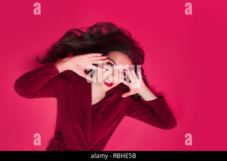 Attractive brunette un ton regard. Portrait of attractive young woman élégant sur fond rose Banque D'Images