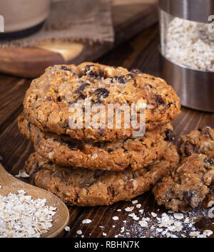 Pile de biscuits à l'avoine et aux raisins et flocons d'avoine sur une surface en bois rustique Banque D'Images