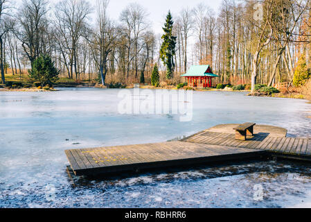 Jetée en bois sur un lac gelé dans un jardin japonais Banque D'Images