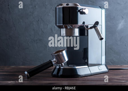 Préparation de l'espresso. Machine à café noir et un avertisseur sonore avec le rez-de grains sur la table. Préparation du café professionnel à la maison Banque D'Images