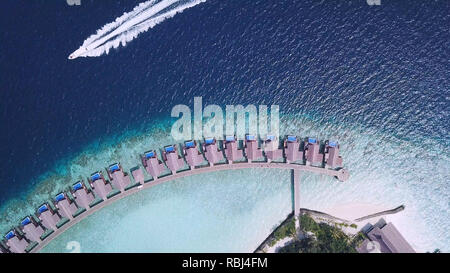 Se déplacer en bateau près de l'océan littoral avec des villas aux Maldives Banque D'Images