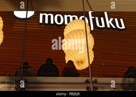 Les gens assis dans la fenêtre de Momofuku Noodle Bar de Nuit sur l'avenue University, Toronto Banque D'Images