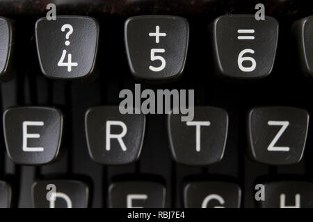 Les clés dans une machine à écrire. Symboles de lettres et chiffres sur le clavier. Fond clair. Banque D'Images
