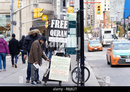 Un musulman à un stand de rue de donner gratuitement des exemplaires du Coran, Toronto, Canada Banque D'Images