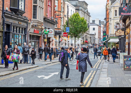 Les gens, les familles, les touristes la marche et à la découverte d'une rue commerciale animée de Dublin, Irlande. Banque D'Images