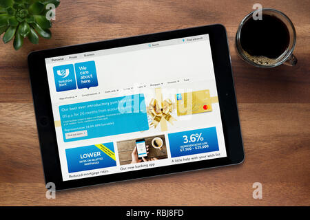Le site internet de Yorkshire Bank est vu sur un iPad tablet, sur une table en bois avec une machine à expresso et d'une plante (usage éditorial uniquement). Banque D'Images