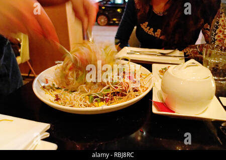 Les mains d'une serveuse de jeter une salade Banque D'Images