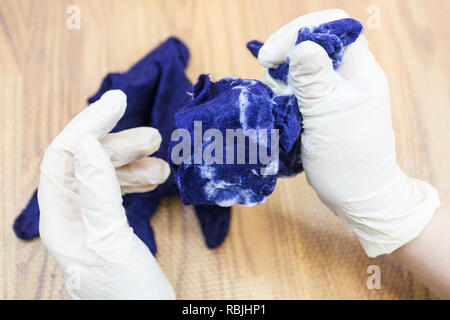 La main de l'atelier faisant un Gants polaire à partir de la laine de mouton mérinos bleu à l'aide de feutrage humide - artisan foulonnage le gant avec de l'eau savon feutré Banque D'Images
