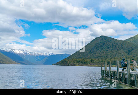 LAKE ROTOROA Nouvelle-zélande - 6 octobre 2018 ; Couple dans des vêtements chauds coin ensemble sur pier s'étendant dans le pittoresque lac entouré de montagnes de Nelso Banque D'Images