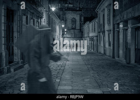 L'ancienne rue de la ville médiévale de nuit avec une mystérieuse figure sinistre en passant par en avant-plan Banque D'Images