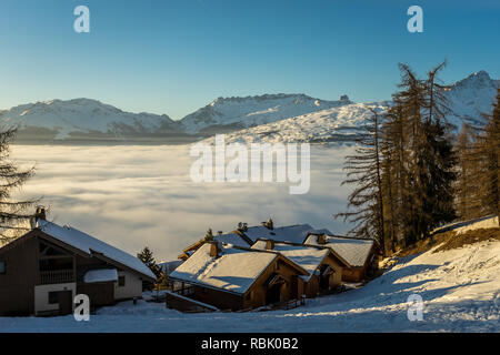 Maisons perchées sur le bord d'un lac de nuages dans la station de ski Les Arcs, France Banque D'Images