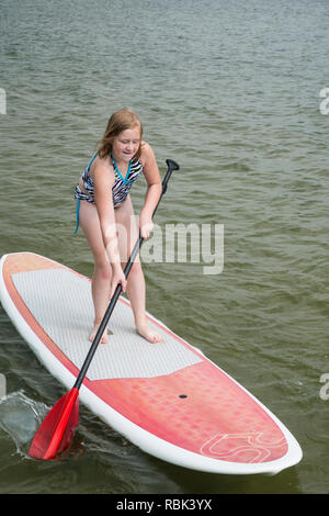 Naytahwaush ; Minnesota. Neuf ans, fille paddle sur un lac. Banque D'Images