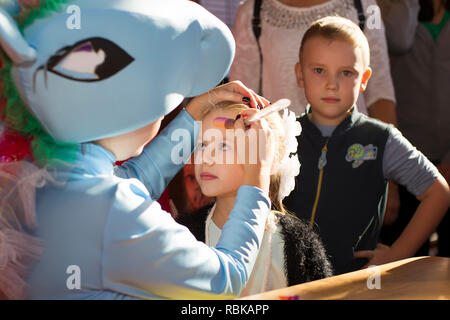 Biélorussie, Minsk, le 13 octobre 2018. Maison de vacances dans la ville. Fête pour les enfants. L'animateur met un visage peinture sur l'enfant. Banque D'Images