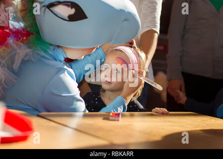 Biélorussie, Minsk, le 13 octobre 2018. Maison de vacances dans la ville. Fête pour les enfants. L'animateur met un visage peinture sur l'enfant. Banque D'Images