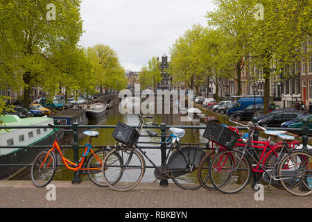 Les vélos garés sur un pont sur un canal à Amsterdam Banque D'Images