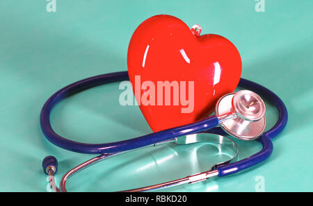 Coeur rouge avec stéthoscope sur fond en bois bleu. Banque D'Images