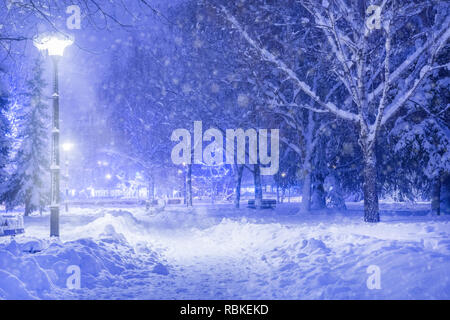 Idylle d'hiver dans le parc la nuit et sentier couvert de grande neige. Lanterne brillant grâce à l'enneigement dans la soirée. La neige et le froid de l'hiver Banque D'Images