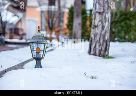 Lanterne de jardin dans le jardin d'hiver au milieu de la neige. Des congères de neige dans le jardin. Banque D'Images