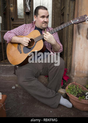 L'homme qui joue de la guitare sur les mesures de Brownstown dans le quartier Park Slope de Brooklyn, New York. Banque D'Images