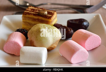 Ensemble de bonbons sur plaque blanche sur table in cafe Banque D'Images