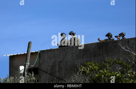 Naplouse, Cisjordanie, territoire palestinien. Jan 11, 2019. Les forces de sécurité israéliennes prendre position au cours d'affrontements avec des manifestants palestiniens à la suite d'une manifestation hebdomadaire contre l'expropriation de terres palestiniennes par Israël dans le village de Kfar Qaddum, près de la ville cisjordanienne de Naplouse le 11 janvier 2019 Credit : Shadi Jarar'Ah/APA/Images/fil ZUMA Alamy Live News Banque D'Images