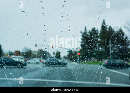 Gouttes de pluie sur le pare-brise en roulant sur un jour de pluie, en Californie Banque D'Images