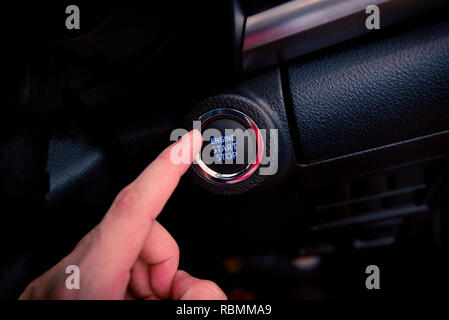 Pousser le bouton de démarrage du moteur de voiture / push start stop en voiture moderne technologie - appuyer sur la touche du doigt la main sur ma voiture Banque D'Images