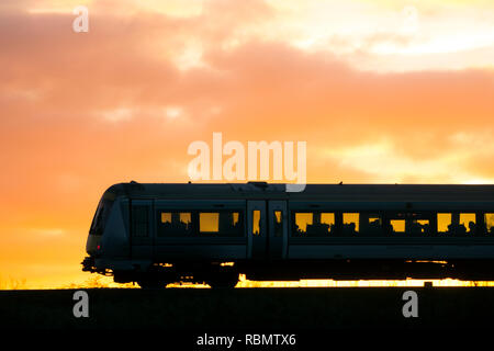 Chiltern Railways train diesel silhouetté au coucher du soleil, dans le Warwickshire, Royaume-Uni Banque D'Images