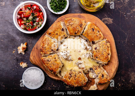 Le camembert cuit au four avec du pain aux herbes servi avec salade de tomates et d'huile d'olive Banque D'Images