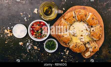 Le camembert cuit au four avec du pain aux herbes servi avec salade de tomates et d'huile d'olive Banque D'Images