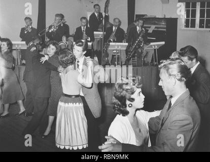 Danser dans les années 50. La piste de danse est remplie de couples de danseurs bien habillé, déménagement à la musique à un club. Un groupe joue sur scène. Suède 1956 Banque D'Images