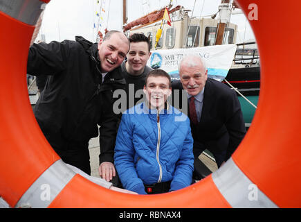 Le ministre de la défense Paul Kehoe (à gauche) et ministre responsable des Personnes Handicapées Finian McGrath (à droite) avec Dylan Nelson (deuxième à droite), de monuments historiques, et David McDonagh, de Ballymun, lors d'une annonce de financement par rapport au développement des jeunes, en collaboration avec des voiliers (Irlande) à Poolbeg STIRL Location de bateau et de Club à Dublin. Banque D'Images