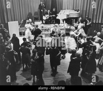 Danser dans les années 60. Un groupe joue et le plancher de danse est remplie de couples de danseurs qui s'amusent. Suède 1960 Banque D'Images