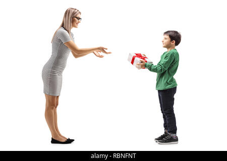 Tourné sur toute la longueur d'un jeune garçon en donnant un cadeau à sa mère isolé sur fond blanc Banque D'Images