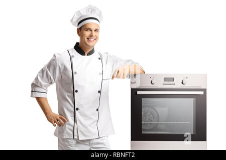 Smiling young male chef debout à côté d'un four isolé sur fond blanc Banque D'Images