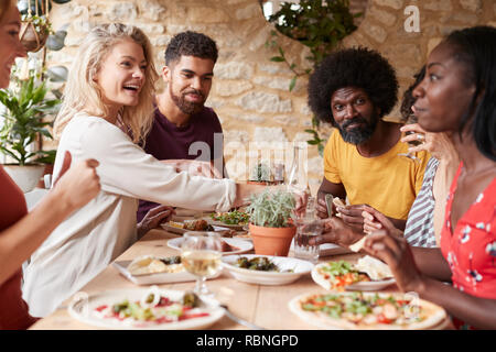 Amis adultes de manger le déjeuner à une table dans un restaurant. Banque D'Images