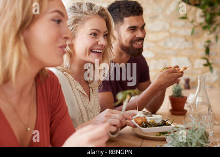 Trois jeunes amis adultes de manger dans un restaurant, Close up Banque D'Images