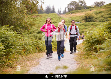 Les parents des enfants en avance sur la marche sur un chemin de pays durant un voyage de camping familial, selective focus Banque D'Images