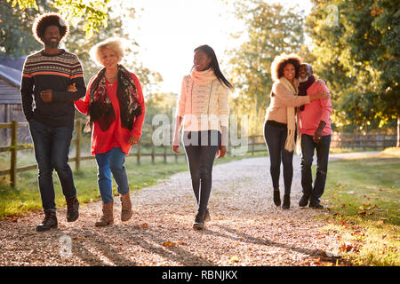 Les parents avec enfants adultes bénéficiant d'automne à pied dans la campagne Ensemble Banque D'Images