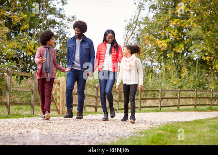 Mixed Race family marcher ensemble sur un chemin de pays, low angle Banque D'Images