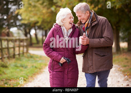 Couple actif sur l'automne à pied sur le chemin dans la campagne Banque D'Images