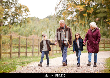 Les grands-parents avec petits-enfants sur l'automne à pied dans la campagne Ensemble Banque D'Images