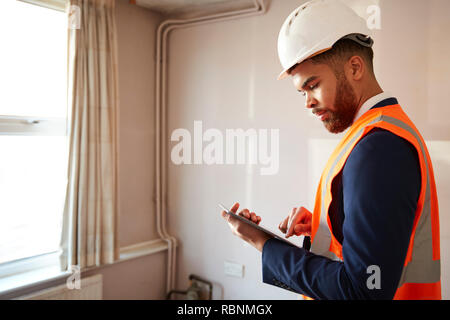 Surveyor Dans Casque et Veste haute visibilité avec tablette numérique l'exécution de l'Inspection de la propriété Banque D'Images