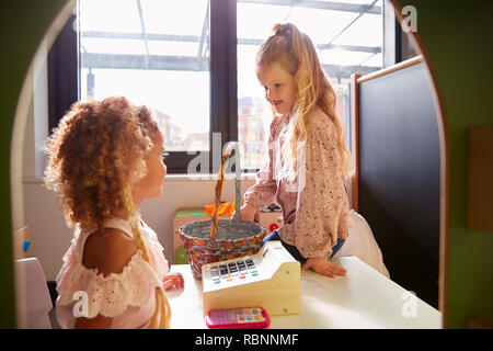 Deux jeunes écolières jouant dans une boutique au Playhouse une petite école, rétroéclairé Banque D'Images