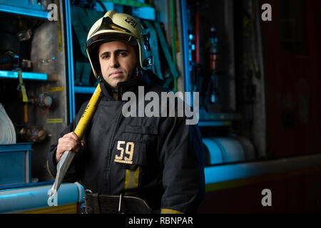 Photo de l'homme pompier avec prise près de camion d'incendie à la station Banque D'Images