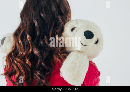 Polar bear hugs jouet curly jeune femme brune en rose lumineux dr Banque D'Images