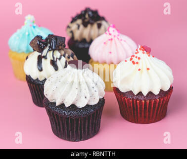 Six mini cupcakes fantaisie sur fond rose Banque D'Images
