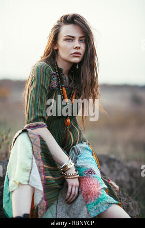 Fashion portrait de jeune femme hippie au coucher du soleil qui posent sur fond nature Banque D'Images